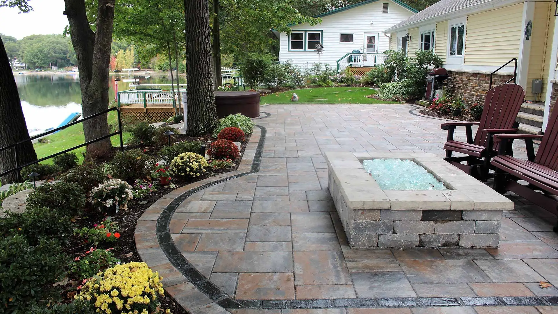 Custom landscape bed and patio installation at a Walker, MI home property.